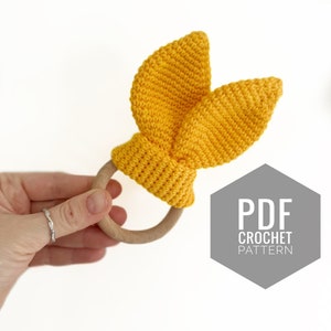 May include: A yellow crocheted bunny rattle with wooden ring. PDF crochet pattern.