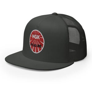 May include: A black and gray trucker hat with a red and white embroidered logo that says "NGK PLUG ME".