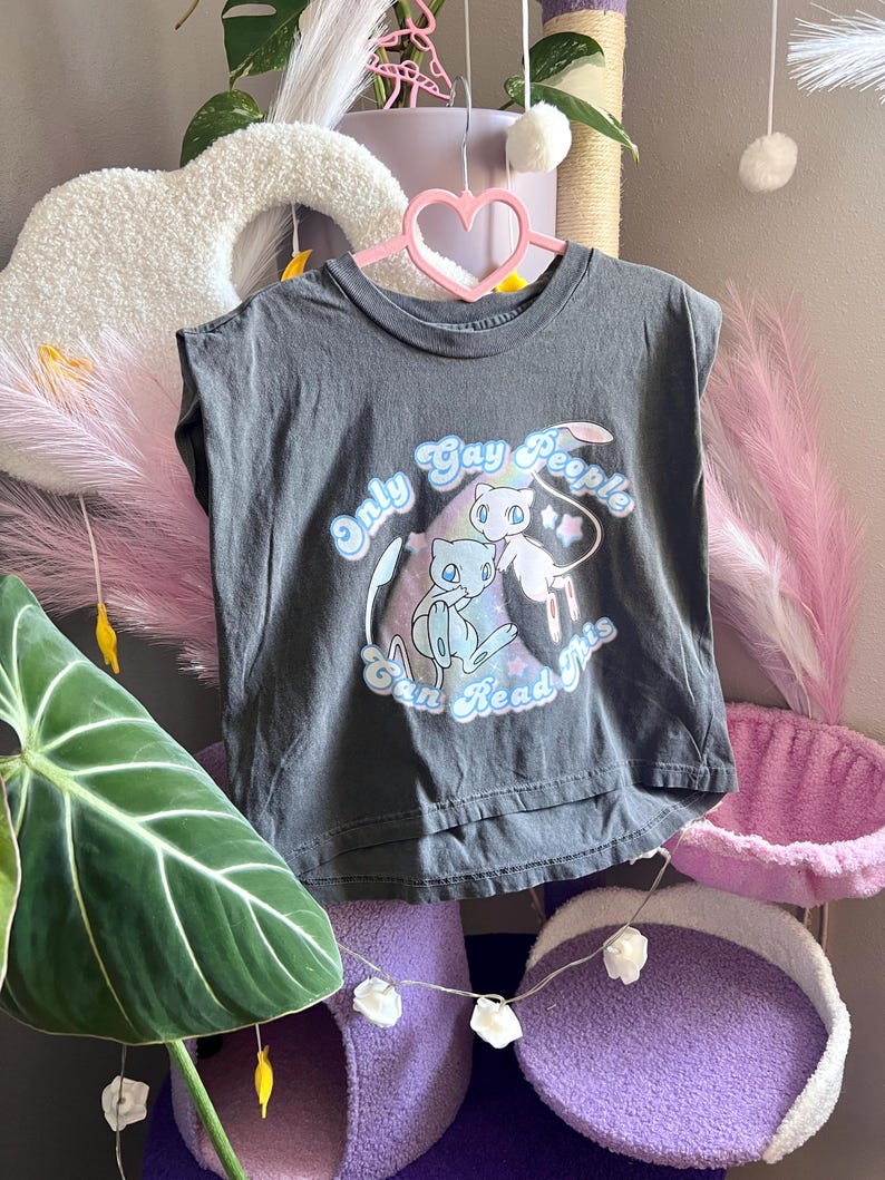 Gray muscle tank with mew and shiny mew, a rainbow is behind them. Surrounding them is the words Only Gay People Can Read This