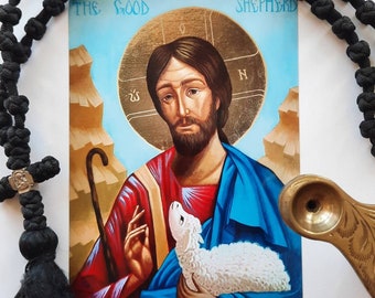 May include: A religious icon depicting The Good Shepherd, a man with a beard and long hair, holding a lamb in his arms. The icon is painted in a traditional style with vibrant colours and gold accents. The text "The Good Shepherd" is written at the top of the icon.