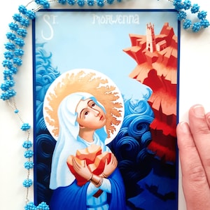 May include: A blue and white religious icon of St. Morwenna holding a heart in her hands. The icon is surrounded by a blue and white rosary.