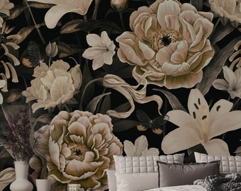 May include: A bedroom interior featuring a dark floral wallpaper with large cream peonies, lilies, and butterflies. The room includes a bed with a light-colored duvet, a gray knit throw, a wooden bench with an open book, and a light wood cabinet.