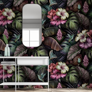 May include: Wallpaper featuring a dark tropical pattern with large green monstera leaves, pink and white hibiscus flowers, purple ginger blossoms, and small hummingbirds. The design is set against a black background, creating a dense botanical display.