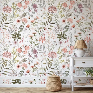 May include: A white wall with a floral wallpaper featuring a variety of pink and green flowers. A white nightstand with a wicker lampshade and a woven basket are in the foreground.