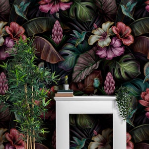 May include: A white fireplace mantel stands against a wall covered in dark wallpaper featuring a tropical pattern of pink and white hibiscus flowers, large green and purple leaves, and small hummingbirds in flight with a potted bamboo plant.