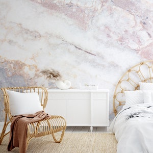 Peut inclure: Une chambre avec un mur au motif de marbre blanc et rose &agrave; grande &eacute;chelle. La pi&egrave;ce comprend une chaise en rotin avec un plaid marron, un buffet blanc et un lit avec une t&ecirc;te de lit en rotin pos&eacute; sur un tapis beige textur&eacute;.