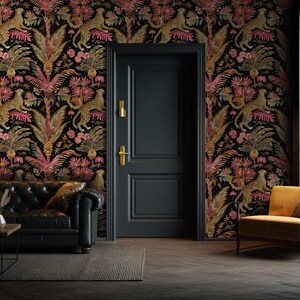 May include: A black door with gold hardware is centered against a wall covered in wallpaper featuring a repeating pattern of leopards, pink tropical flowers, and green palm leaves. A black leather sofa and a yellow armchair are positioned nearby.
