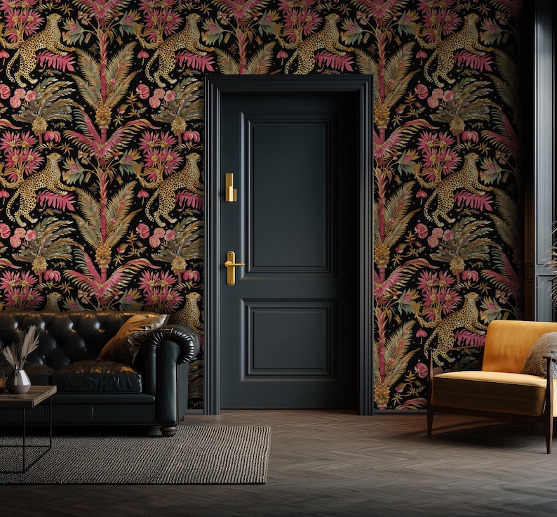 May include: A black door with gold hardware is centered against a wall covered in wallpaper featuring a repeating pattern of leopards, pink tropical flowers, and green palm leaves. A black leather sofa and a yellow armchair are positioned nearby.