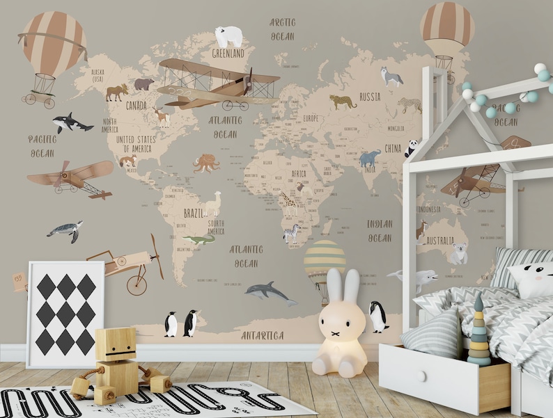 K&ouml;nnte beinhalten: Ein Wandbild mit einer Weltkarte in gedeckten Beige- und Braunt&ouml;nen, verziert mit Illustrationen von Tieren, Flugzeugen und Hei&szlig;luftballons. Die Karte enth&auml;lt Beschriftungen f&uuml;r Kontinente und Ozeane, daneben steht ein wei&szlig;es Hausbettgestell.