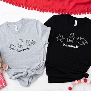 two t - shirts and a teddy bear on a table