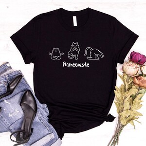 a black t - shirt with a picture of two cats on it