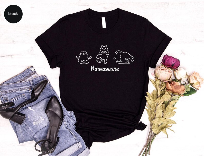 a black t - shirt with a picture of two cats on it