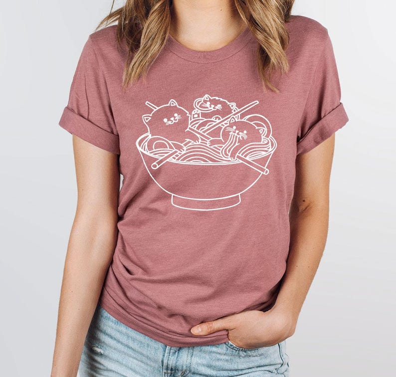 a woman wearing a t - shirt with a picture of a bowl of noodles
