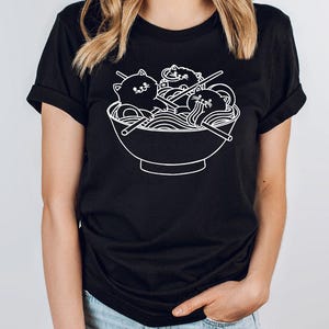 a woman wearing a black tshirt with a bowl of noodles on it