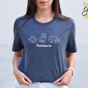 a woman wearing a blue t - shirt with the name namonosuit on it