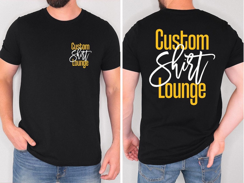 May include: Black t-shirt with the text "Custom Shirt Lounge" in white and yellow. The text is on the front left chest and the back of the shirt. The shirt is a crew neck and has short sleeves. The model is wearing blue jeans.