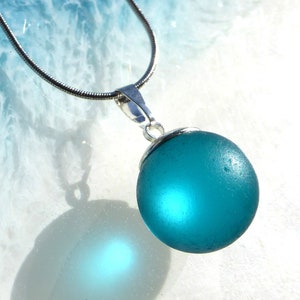 Pendant made of petrol-colored sea glass ball with silver-colored loop