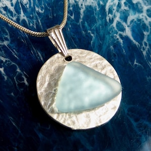 silver tone pendant hammered with light blue sea glass