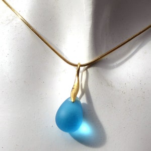 Pendant made of a turquoise glass drop with a golden loop