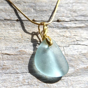 Pendant made of light turquoise sea glass with a gold-plated loop.