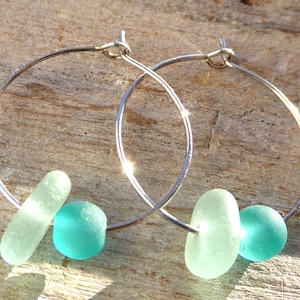 silver-colored hoop earrings with sea glass in light turquoise and petrol-colored beads