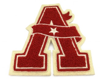 May include: Red felt letter A with a white star and a white banner. The letter is outlined in white.