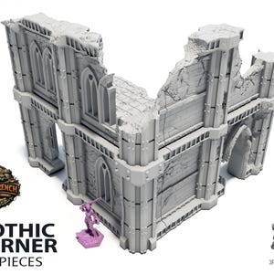 Op de afbeelding: Een grijs hoekgebouwmodel in gotische stijl met een beschadigde gevel. Het model heeft boogvensters en een gedeeltelijk ingestort dak. De tekst "GOTHIC CORNER 3 PIECES" wordt weergegeven. Een klein paars beeldje staat bij het model.