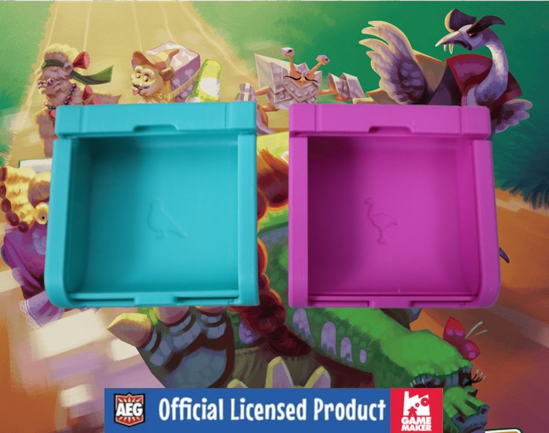 Puede incluir: Dos cajas de almacenamiento de pl&aacute;stico con tapas, una azul y otra rosa, con un logotipo de p&aacute;jaro en la parte delantera. Las cajas est&aacute;n sobre un fondo de dibujos animados colorido con el texto "Producto con licencia oficial" y los logotipos de AEG y Game Maker.