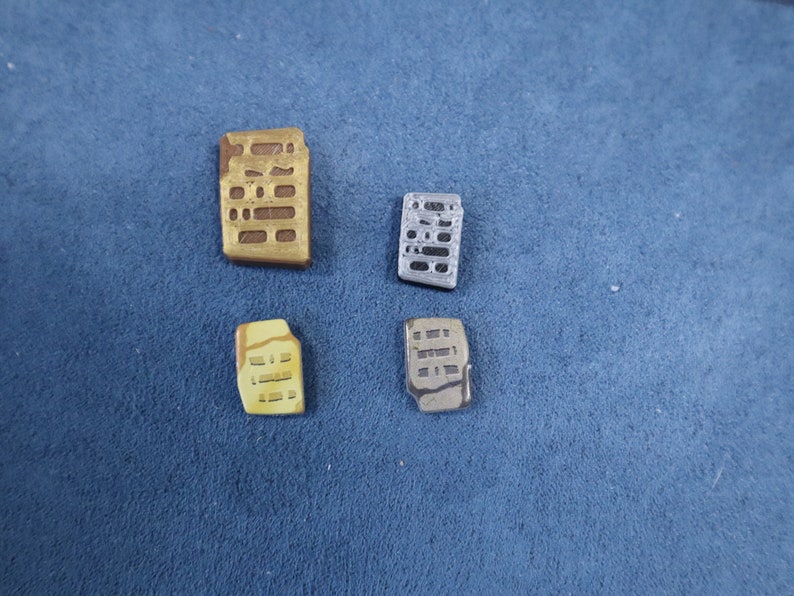 May include: Four small ceramic tiles with a grid pattern. The tiles are in shades of brown, yellow, and gray.