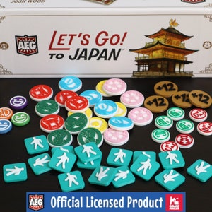 May include: A game box with the text "Let's Go! To Japan" and a colorful assortment of game pieces, including tokens, dice, and player markers. The box is white with red and black accents. The game pieces are made of plastic and are in various colors, including red, blue, green, yellow, and white.