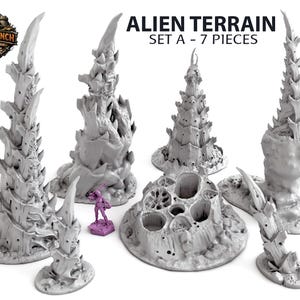 Puede incluir: Un conjunto de siete piezas de terreno alienígena grises para juegos de mesa. Las piezas incluyen estructuras puntiagudas y una base circular porosa. El texto "ALIEN TERRAIN SET A - 7 PIECES" se muestra en negro.