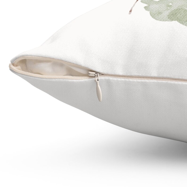 May include: White pillow with a zipper closure. The zipper is open and the zipper pull is visible.