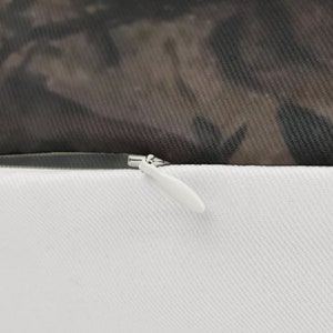 May include: Close-up of a zipper on a white pillowcase. The zipper is silver and has a white pull tab. The pillowcase is made of a soft, white fabric.