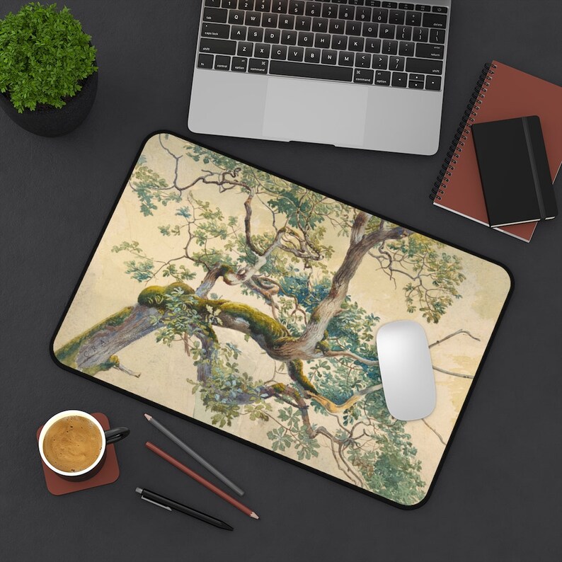 May include: A mouse pad with a watercolor painting of a tree branch with green leaves on a beige background.