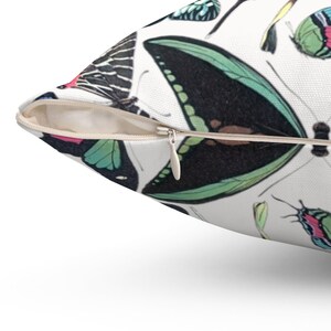 May include: A white pillowcase with a zipper closure features a colorful butterfly pattern. The butterflies are arranged in a random pattern and are in various shades of blue, green, pink, and black.