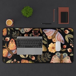 Peut inclure: Un tapis de bureau noir avec un motif r&eacute;p&eacute;titif de papillons color&eacute;s, de fleurs et de baies. Le tapis est d&eacute;cor&eacute; d'un design de style aquarelle.
