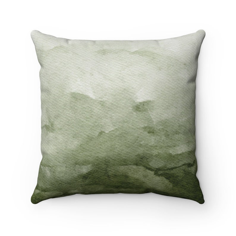 May include: A green watercolor throw pillow with a soft, abstract design. The pillow is made of a soft, comfortable fabric and is perfect for adding a touch of color and style to any room.