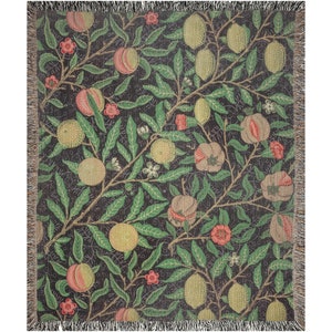May include: A woven throw blanket with a repeating pattern of pomegranates, lemons, and leaves on a dark background. The pattern is in shades of green, red, yellow, and brown.