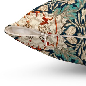 Pode incluir: Uma almofada de arremesso com fecho de correr, apresentando um padr&atilde;o floral em tons de azul, branco, laranja e vermelho. A almofada tem uma est&eacute;tica vintage e um design detalhado.
