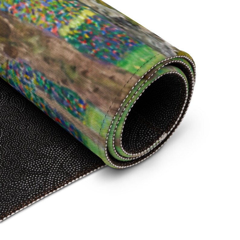 May include: A rolled up rug with a colorful abstract design. The rug has a black non-slip backing.