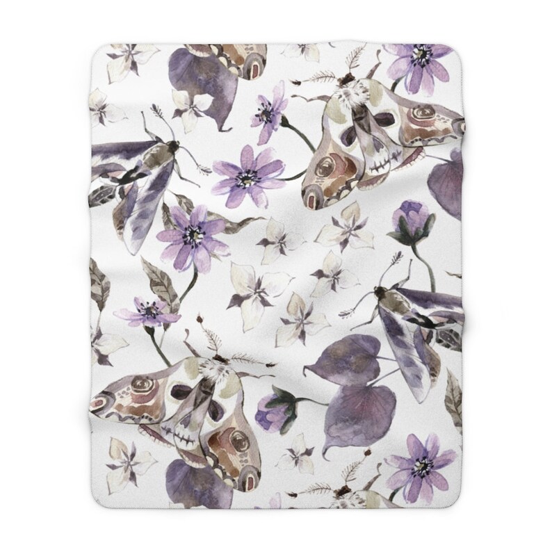 May include: A white background with a repeating pattern of purple flowers, leaves, and moths. The moths have a skull and crossbones design on their wings.