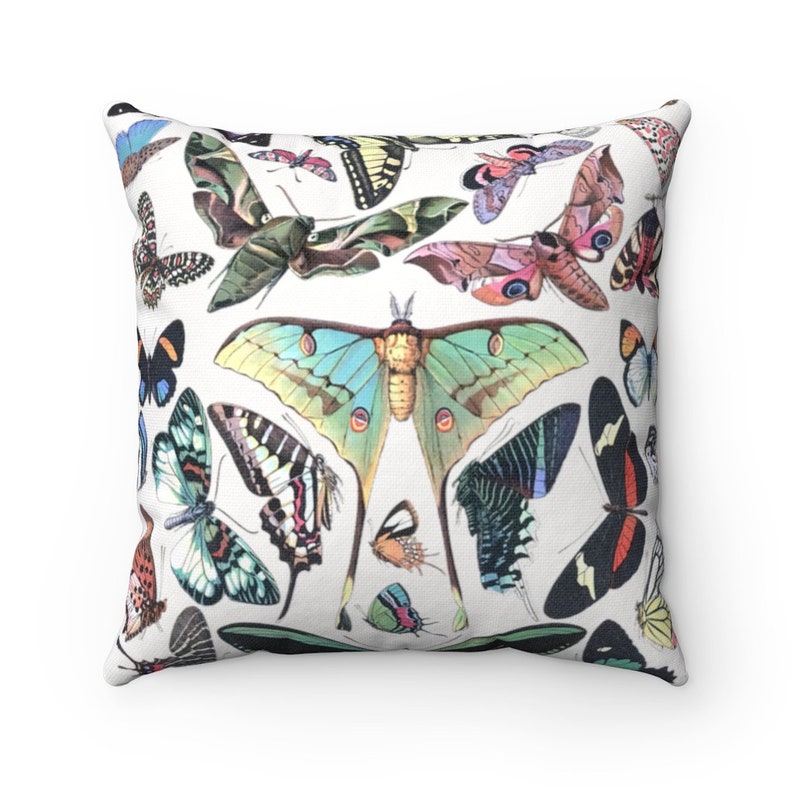 May include: A white throw pillow with a colorful butterfly pattern. The butterflies are in various shades of blue, green, pink, orange, and yellow. The pillow is made of a soft, comfortable fabric and is perfect for adding a touch of whimsy to any room.