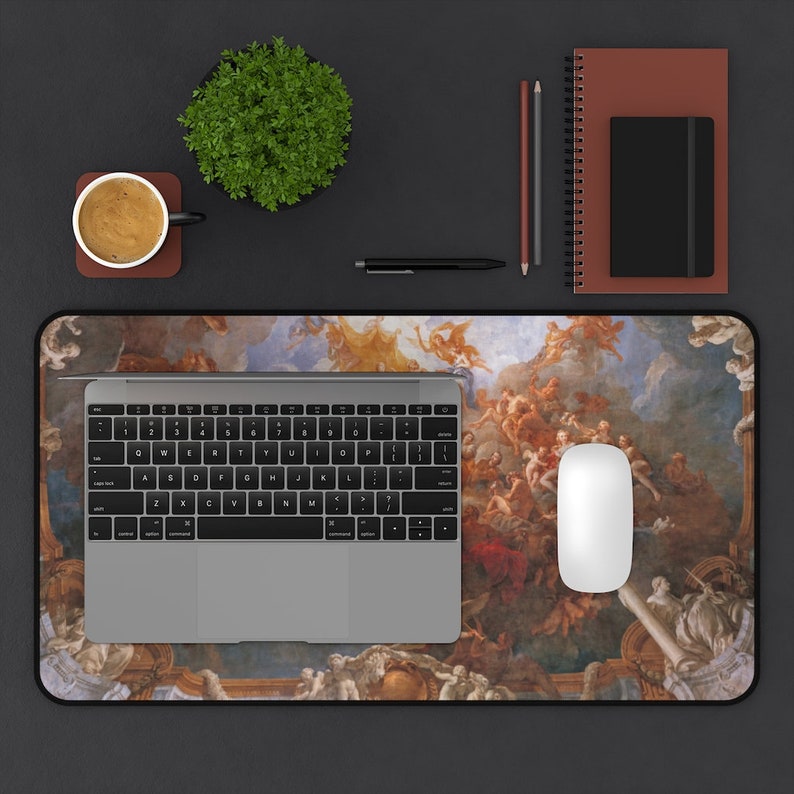 May include: A desk mat with a colorful painting of a ceiling fresco. The painting features angels and clouds. A laptop, a mouse, and a coffee cup are on the desk mat.