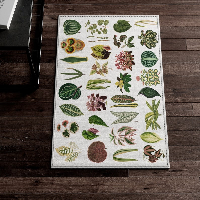 May include: A white rug with a botanical print featuring various green leaves and flowers. The rug is decorated with a variety of plant species, including ferns, palms, and flowering plants.