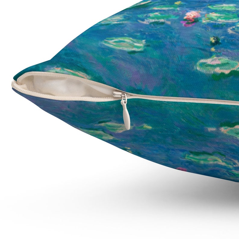 May include: A blue and green throw pillow with a zipper closure. The pillow features a watercolor-style abstract design with shades of blue, green, and pink.