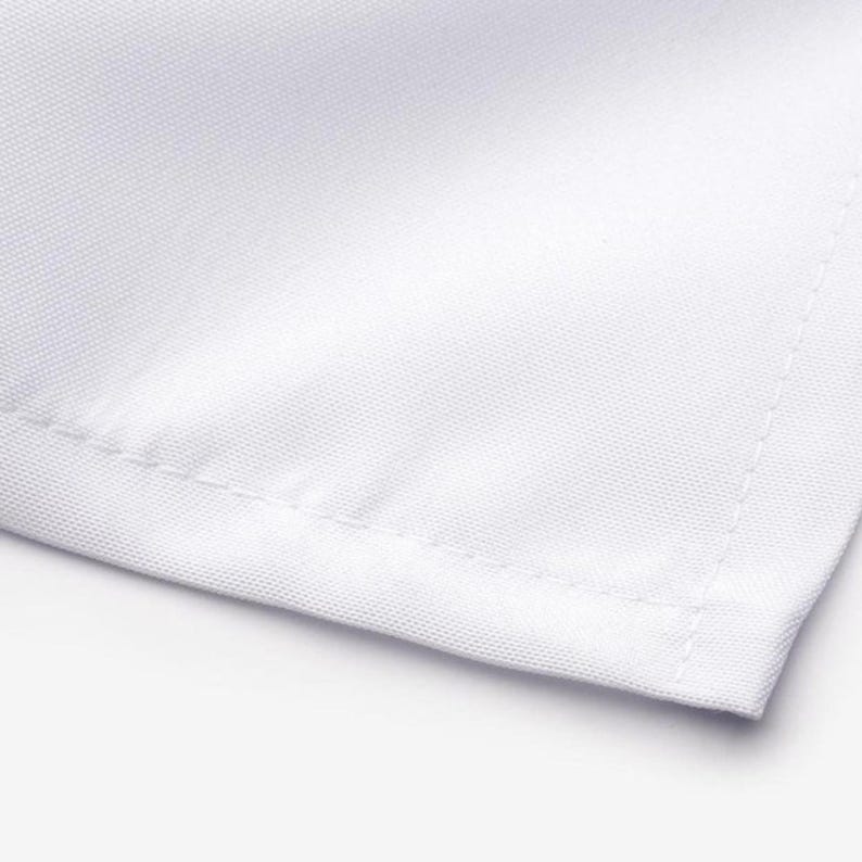 A close-up view of a white fabric, possibly a sheet or a towel, with a slight crease visible at the edge.