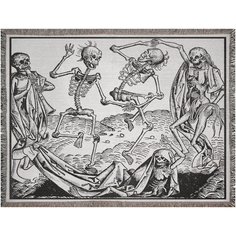 May include: A woven throw blanket featuring a black and white illustration of dancing skeletons. The design includes figures playing instruments and draped in fabric, with a fringed border. The artwork has a vintage, gothic aesthetic.