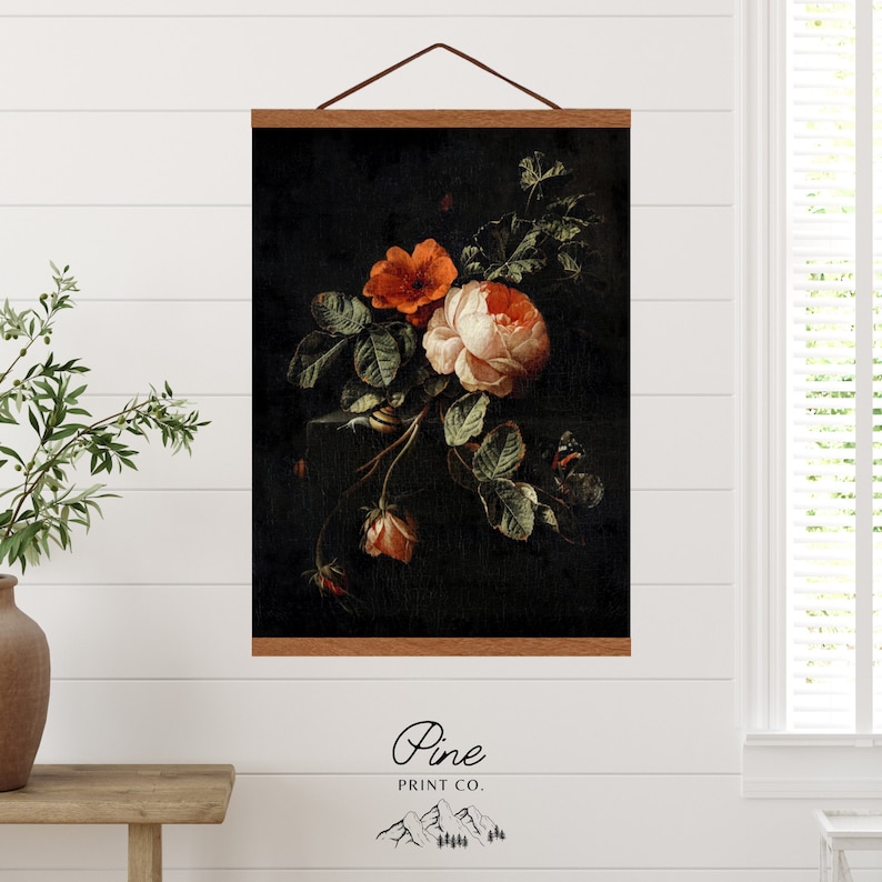May include: A vintage-style print of a bouquet of roses in shades of pink, orange, and red against a dark background. The roses are arranged in a loose, natural style, with some of the petals falling off. The print is framed in a dark wood frame with a hanging system.