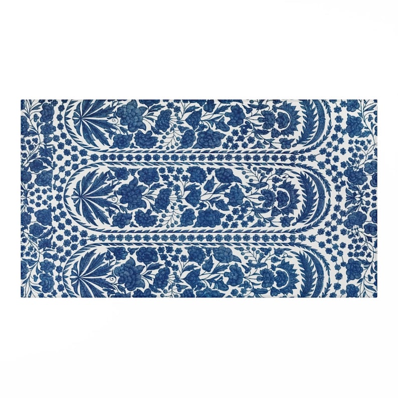 May include: A rectangular, white and blue floral patterned rug. The rug features a repeating design of blue flowers and leaves on a white background. The design is symmetrical, with a central oval shape and floral borders.