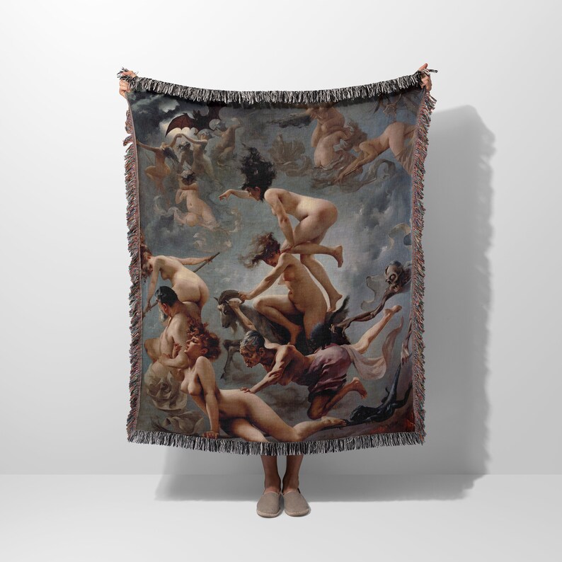 May include: A woven tapestry throw blanket featuring a vintage painting of nude figures in a swirling, cloudy sky. The figures are depicted in various poses, some riding on a goat, others flying through the air. The tapestry is a rich blend of brown, beige, and grey tones.